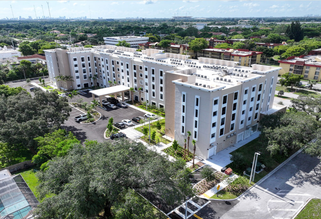 Pinnacle at La Cabaña affordable senior living development in Miramar, Florida, showing controlled-access entry, landscaped pathways, and convenient parking for residents.